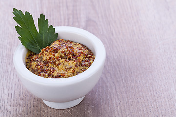 Image showing fresh yellow mustard in white bowl with parsley decorated