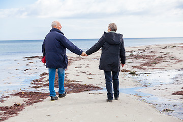 Image showing happy elderly senior couple walking on beach