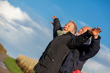 Image showing Elderly couple embracing and celebrating the sun