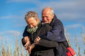 Image showing Elderly couple embracing and celebrating the sun