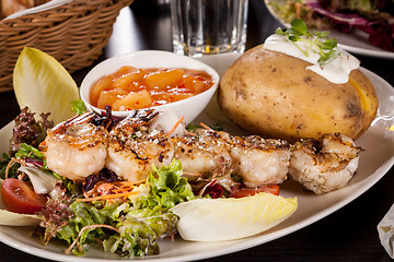 Image showing Grilled prawns with endive salad and jacket potato