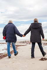 Image showing happy elderly senior couple walking on beach