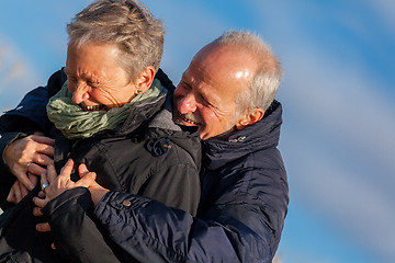 Image showing Elderly couple embracing and celebrating the sun