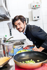 Image showing Chef cooking a vegetables stir fry over a hob