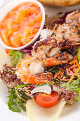 Image showing Grilled prawns with endive salad and jacket potato