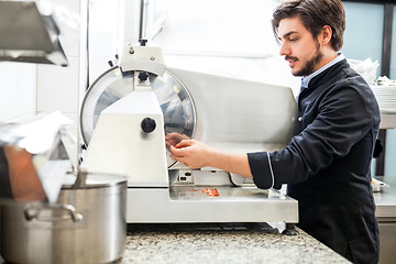 Image showing Commercial cook or chef slicing cold meat