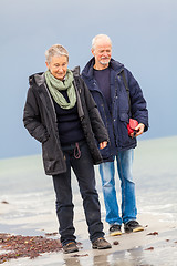 Image showing happy elderly senior couple walking on beach