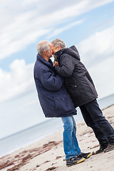 Image showing happy elderly senior couple walking on beach