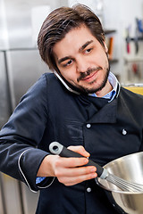 Image showing Chef taking a call on his smartphone