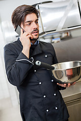 Image showing Chef taking a call on his smartphone