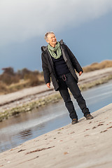 Image showing Happy senior woman frolicking on the beach