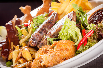 Image showing Platter of mixed meats, salad and French fries