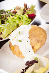 Image showing Baked jacket potato with sour cream sauce