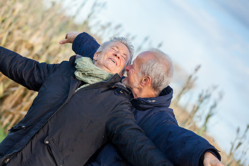 Image showing Elderly couple embracing and celebrating the sun