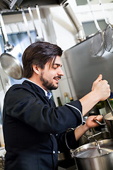 Image showing Chef stirring a huge pot of stew or casserole