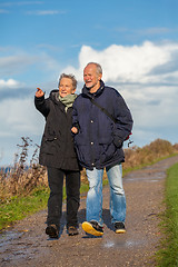 Image showing happy elderly senior couple walking on beach