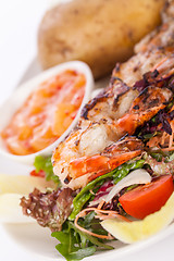 Image showing Grilled prawns with endive salad and jacket potato