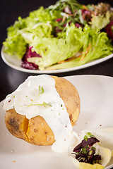 Image showing Baked jacket potato with sour cream sauce