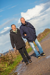 Image showing happy elderly senior couple walking on beach