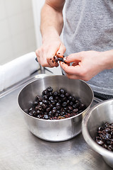 Image showing Chef preparing ingredients in a commercial kitchen