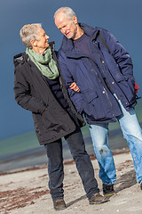 Image showing happy elderly senior couple walking on beach