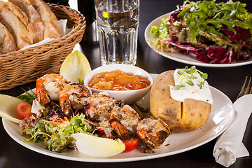 Image showing Grilled prawns with endive salad and jacket potato