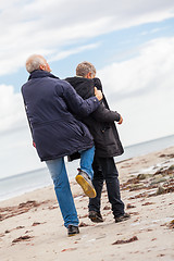 Image showing happy elderly senior couple walking on beach