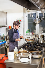 Image showing Chef cooking a vegetables stir fry over a hob