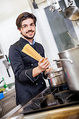 Image showing Attractive friendly chef preparing spaghetti