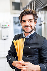 Image showing Attractive friendly chef preparing spaghetti