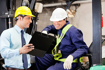 Image showing Supervisor Showing Clipboard To Forklift Driver