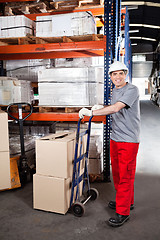 Image showing Warehouse Worker With Handtruck Loading Cardboard Boxes