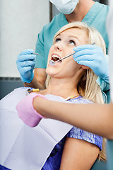 Image showing Dentists Treating A Female Patient At Clinic