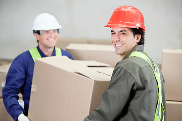 Image showing Foremen Lifting Cardboard Box At Warehouse