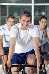 Image showing Three People On Exercise Bikes