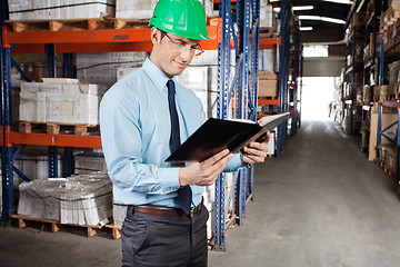 Image showing Supervisor Reading Book At Warehouse