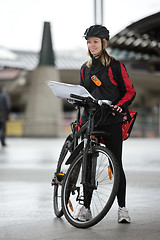 Image showing Female Cyclist With Courier Bag And Package On Street