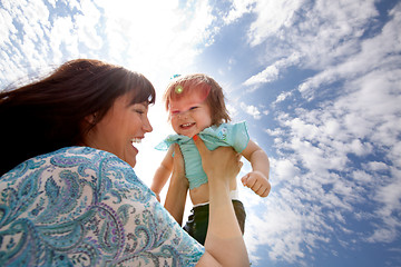 Image showing Mother Holding Daughter in Air