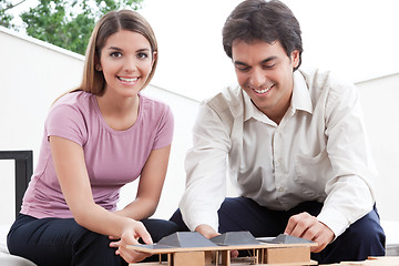 Image showing Two Architects Building a House Model