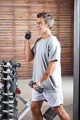 Image showing Man Lifting Dumbbells In Health Center