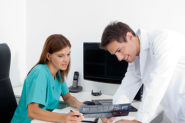 Image showing Dentist With Assistant Analyzing X-Ray Report