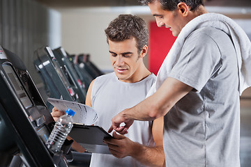 Image showing Instructor Guiding Man To Fill The Membership Form