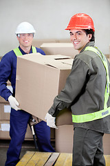Image showing Foremen Lifting Cardboard Box in Warehouse