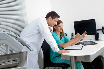 Image showing Dentist With Assistant Analyzing Report