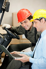 Image showing Male Supervisor And Forklift Driver Using Laptop