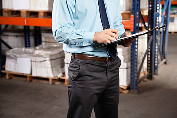 Image showing Supervisor Writing On Clipboard At Warehouse