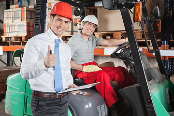 Image showing Supervisor Gesturing Thumbs Up At Warehouse