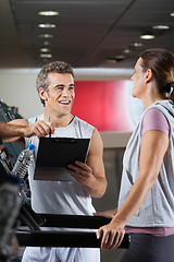 Image showing Happy Instructor Looking At Client Exercising On Treadmill