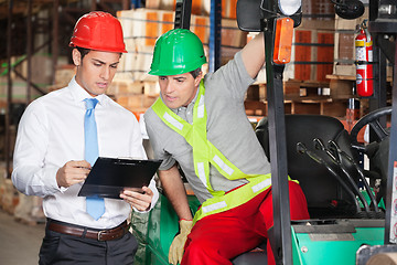 Image showing Supervisor Showing Clipboard To Forklift Driver