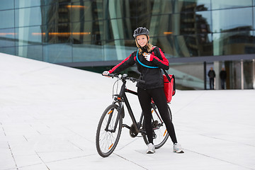 Image showing Female Cyclist With Courier Delivery Bag Using Walkie-Talkie